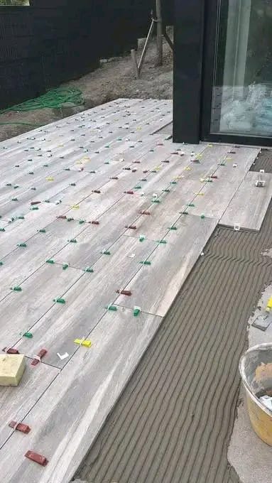 Timber-look tiles being laid on an outdoor deck